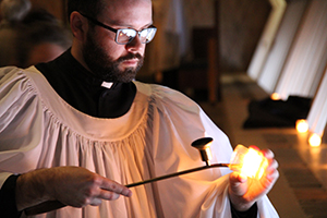 Seminarian Timothy Bayer lights candles in Kramer Chapel for Vespers.