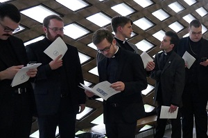 Candidates read their bulletins and silence their cell phones as they line up in anticipation of entering Kramer Chapel to receive their calls.